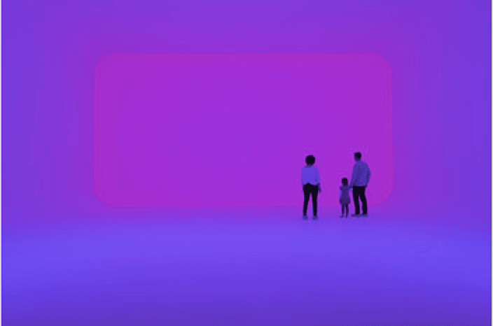 Museum patrons admiring a neon light exhibit