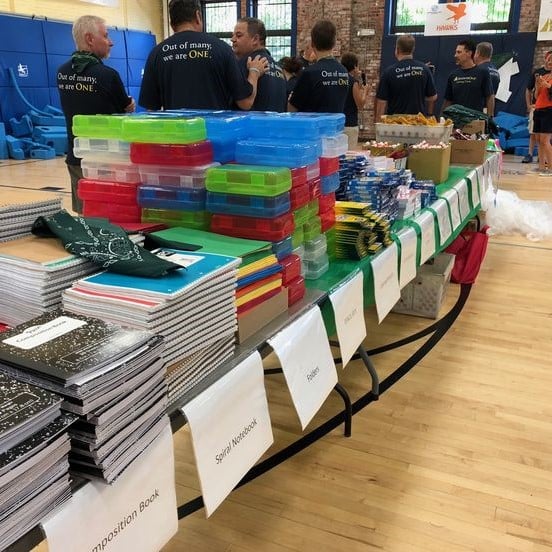 Table full of pencil cases, notebooks, and other school supplies.